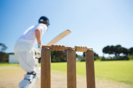 Close up of wooden stump by batsman standing on field