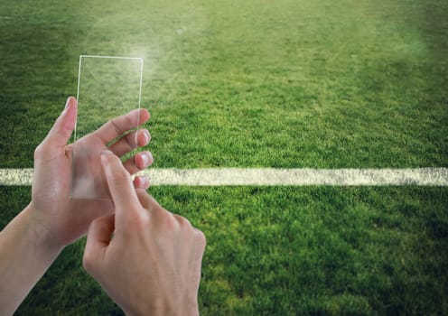 Hand touching glass screen on sports pitch