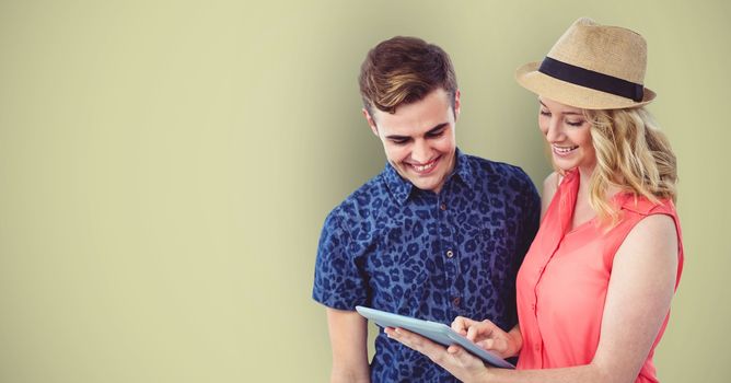 Smiling hipsters using digital tablet against green background