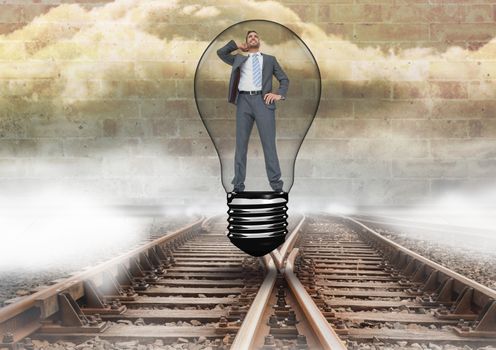 Businessman in light bulb over tracks