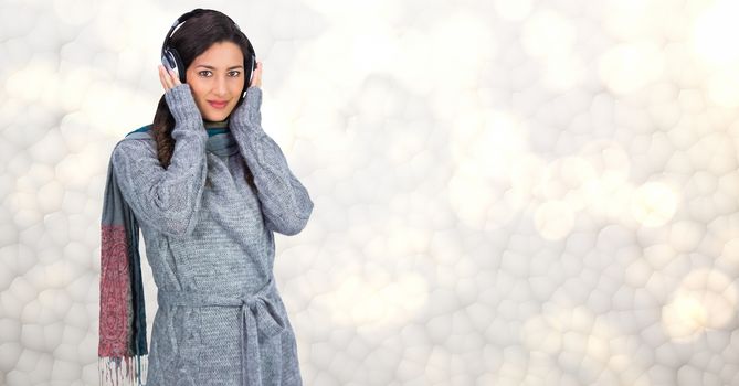 Woman in winter coat listening to music on headphones