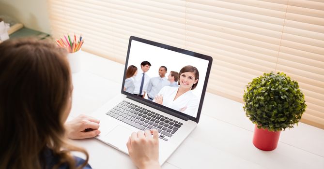 Woman video conferencing with colleagues on laptop