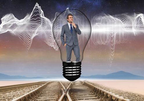 Businessman in light bulb over tracks