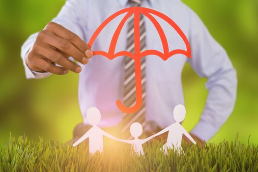 Composite image of family protected by a red umbrella