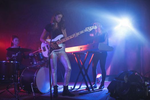 Females performing on illuminated stage in nightclub