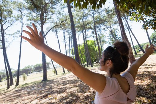 Woman standing with arms outstretched in the park