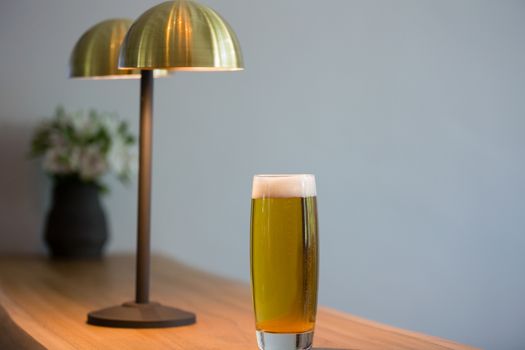 Close up of beer glass by lighting equipment in restaurant