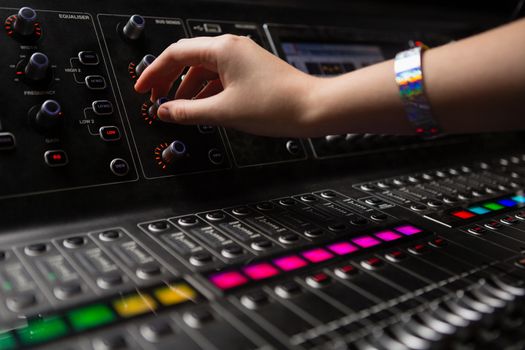 Hand of female audio engineer using sound mixer