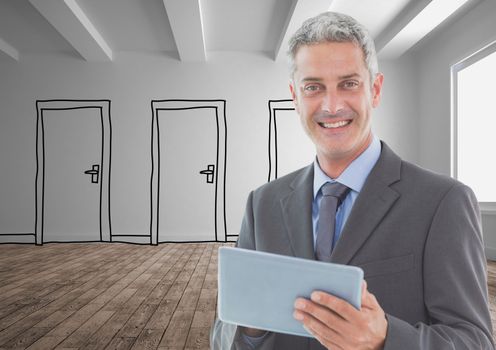 Smiling businessman holding digital tablet standing on hardwood floor against doors