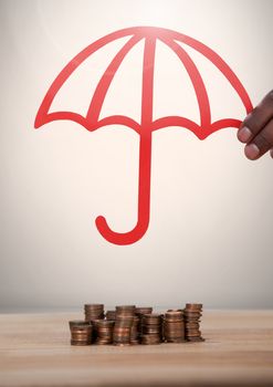 Cut out of umbrella protecting money coins