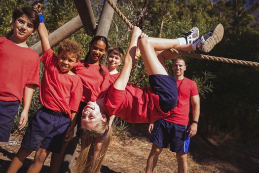Kids climbing a traverse rope during obstacle course training