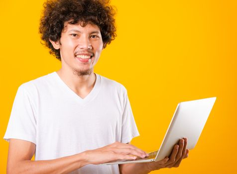 Asian handsome man with curly hair using laptop computer isolate