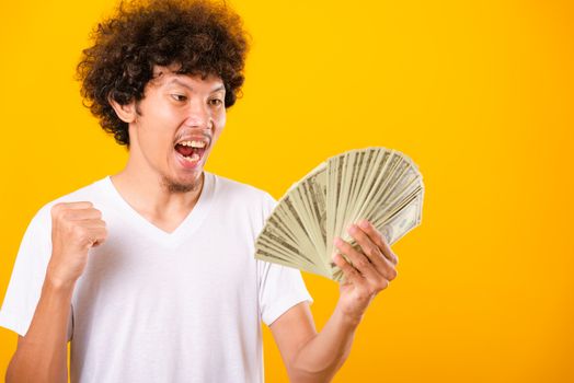 Asian handsome man with curly hair holding fans of money dollar 