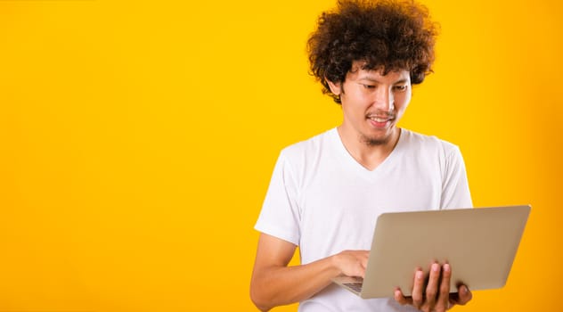 Asian handsome man with curly hair using laptop computer isolate