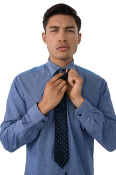 Portrait of businessman adjusting necktie