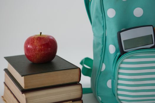 Apple, books, calculator and schoolbag on white background