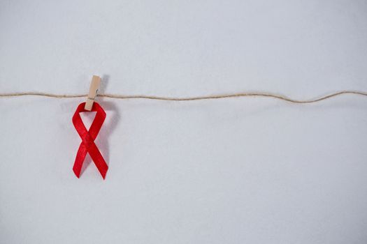 Close-up of red ribbon hanging from clothespin on string