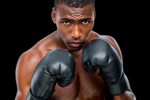 Portrait of shirtless muscular boxer in defensive stance