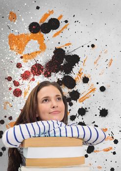 Young student woman looking up against grey, yellow and black splattered background