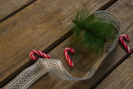 Candy canes with twigs and ribbon on table