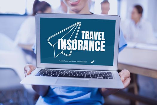 Woman holding a computer with travel insurance concept on screen