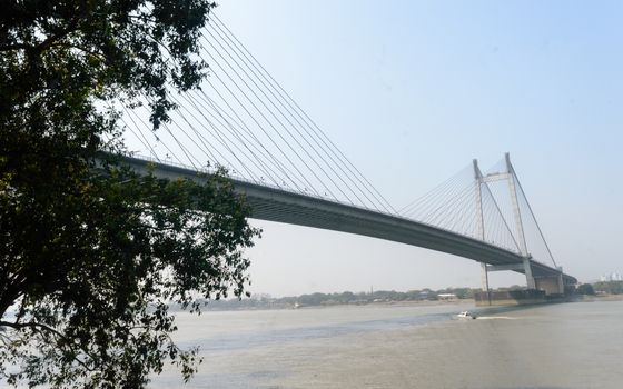 Panoramic Vidyasagar Setu or Hooghly Bridge during sunset. Famous longest cable stayed toll flyover over Ganges River connection cities Kolkata and Howrah. Calcutta West Bengal India South Asia Pac.