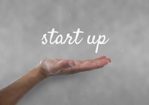 Hand interacting with start-up business text against grey background