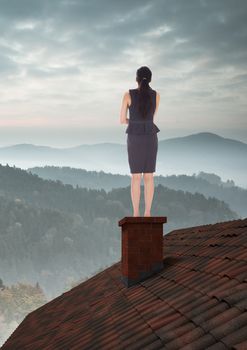 Businesswoman on roof with misty landscape