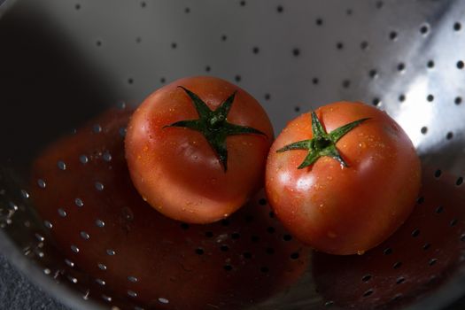 Fresh wet tomatoes in strainer