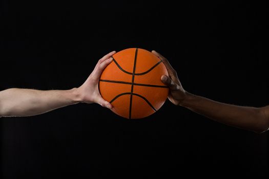 Competitors holding basketball against black background