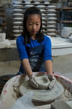 Attentive girl molding a clay