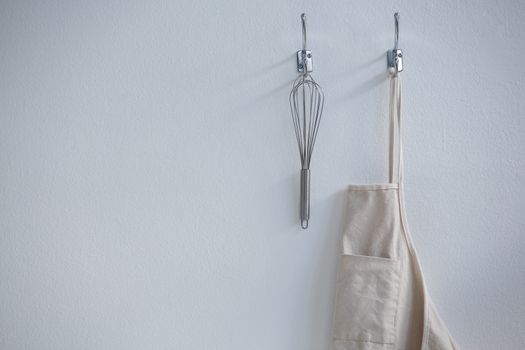 Apron and whisker hanging on hook
