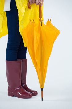 Woman in yellow raincoat holding an umbrella