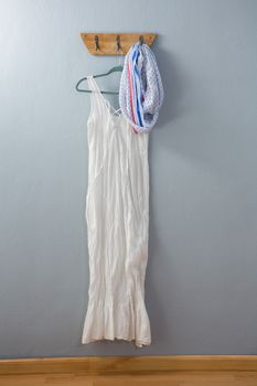 White dress and scarf hanging on hook