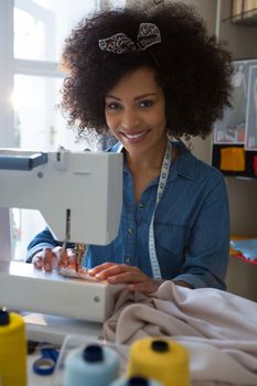 Female fashion designer stitching cloth in sewing machine