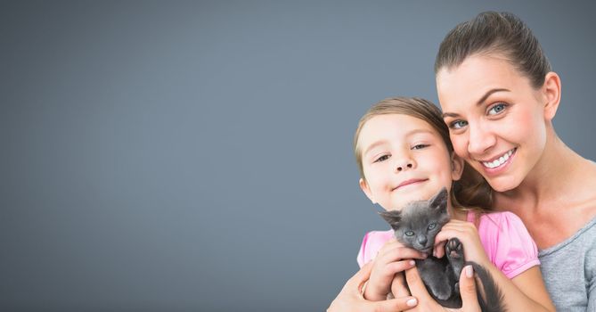 Mother and daughter holding cat with grey background