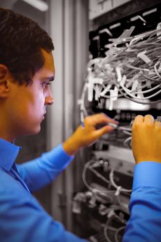 Technician checking cables in a rack mounted server 