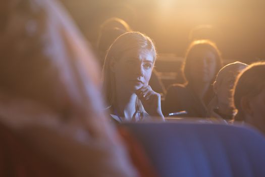 Businesswoman sitting and listening to the presentation with concentration in auditorium