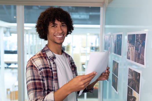 Happy male graphic designer holding a paper