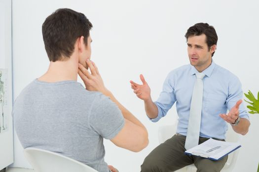 Well dressed male doctor in conversation with patient
