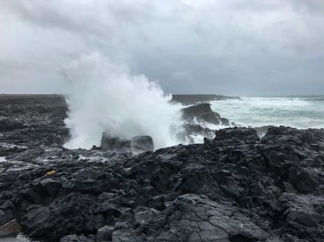 Brimketill lava rock pool in Iceland spray of huge wave
