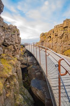 Thingvellir National Park in Iceland during sunny weather hiking path bridging over canyon
