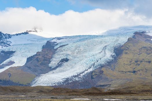 Vatnajoekull glacier in Iceland spiky crevasse in deep blue color flowing down the mountain