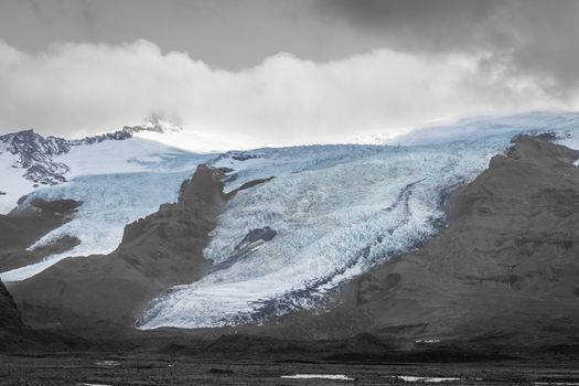 Vatnajoekull glacier in Iceland spiky crevasse in black and white with blue accent colored ice