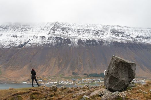 Westfjords of Iceland Naustahvilft The Troll Seat person looking towards Isafjoerdur