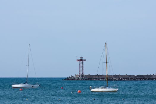 Sailing Boats And Harbor Lighthouse Beacon