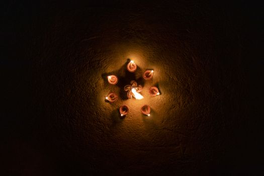 Glowing multiple clay lamp in dark night on the floor- Happy Diwali, Light festival, Illuminated lights
