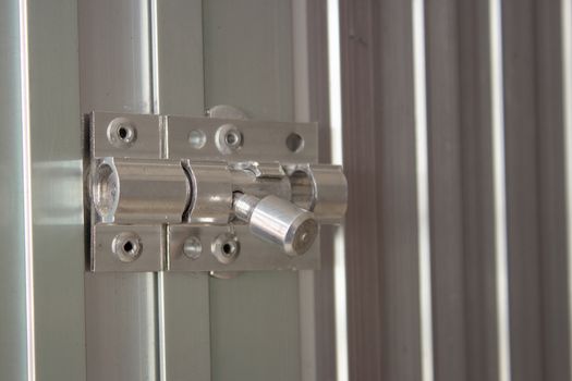 Aluminum latch on an aluminum door frame, brand new and shiny