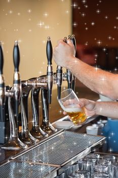 Composite image of barman pulling a pint of beer