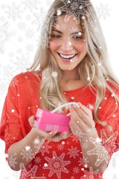 Composite image of blonde woman discovering necklace in a gift box